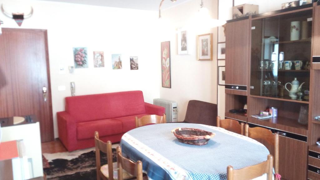 a living room with a table and a red couch at Villaggio Bianco in San Giacomo