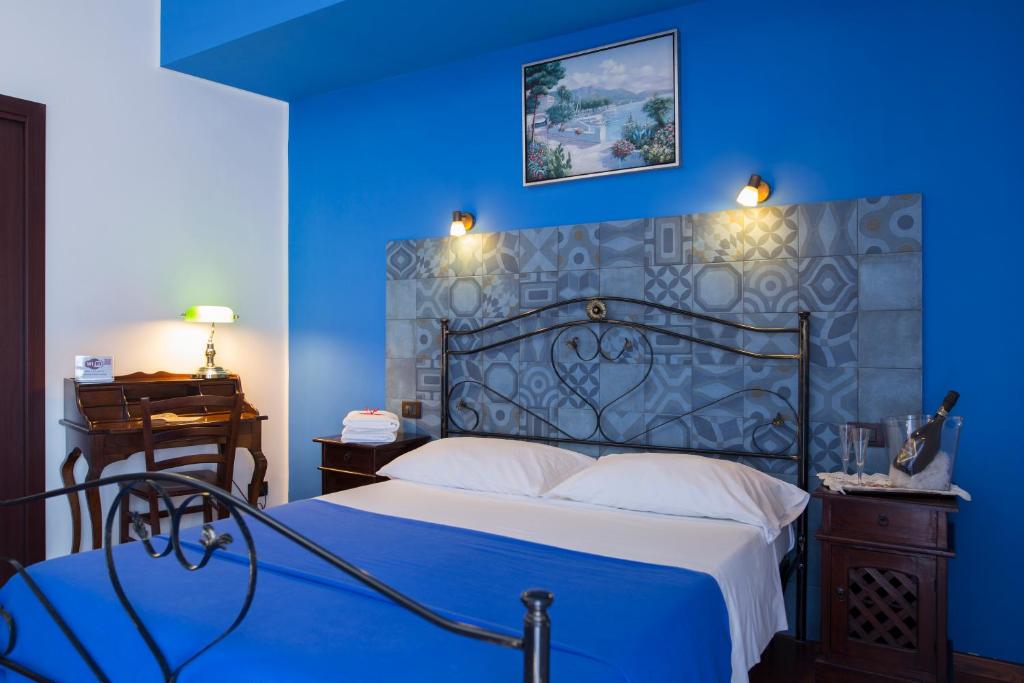 Dormitorio azul con cama y pared azul en Le Cinque Novelle, en Agrigento