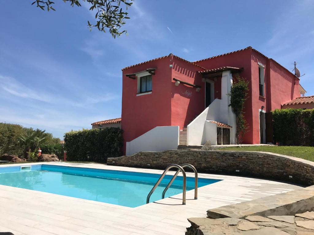 uma villa com piscina em frente a uma casa em Villa Angeli Luxury Piscina Esclusiva em Stintino