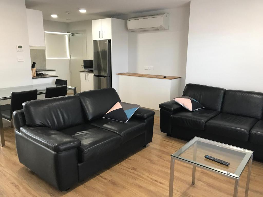 - un salon avec un canapé en cuir noir et une table dans l'établissement Jesmond Executive Villas, à Newcastle