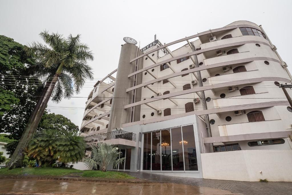 un edificio con una palmera delante en Piloes Palace Hotel, en Mineiros