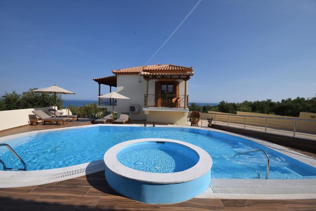 a swimming pool in front of a villa at Driopes Villas in Koroni