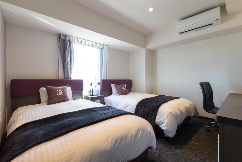 a hotel room with two beds and a window at Green Rich Hotel Izumo (Artificial hot spring Futamata Yunohana) in Izumo