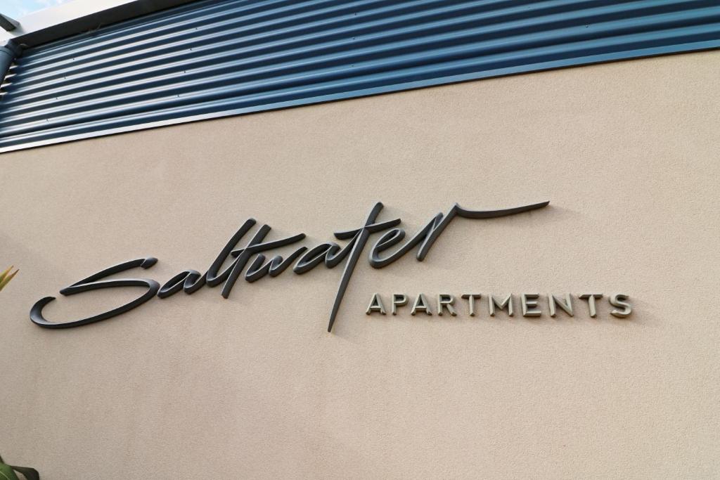 una señal en el lateral de un edificio en Saltwater Apartments, en Eden