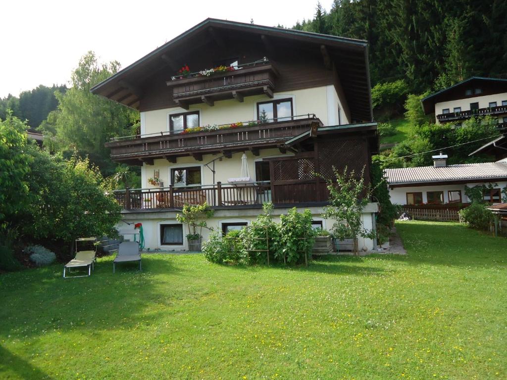 a large house with a balcony and a yard at Appartement Pleikner in Neukirchen am Großvenediger