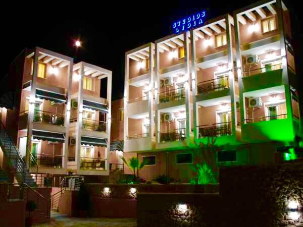 a large building with a neon sign in front of it at Lydia Studios in Skala Marion