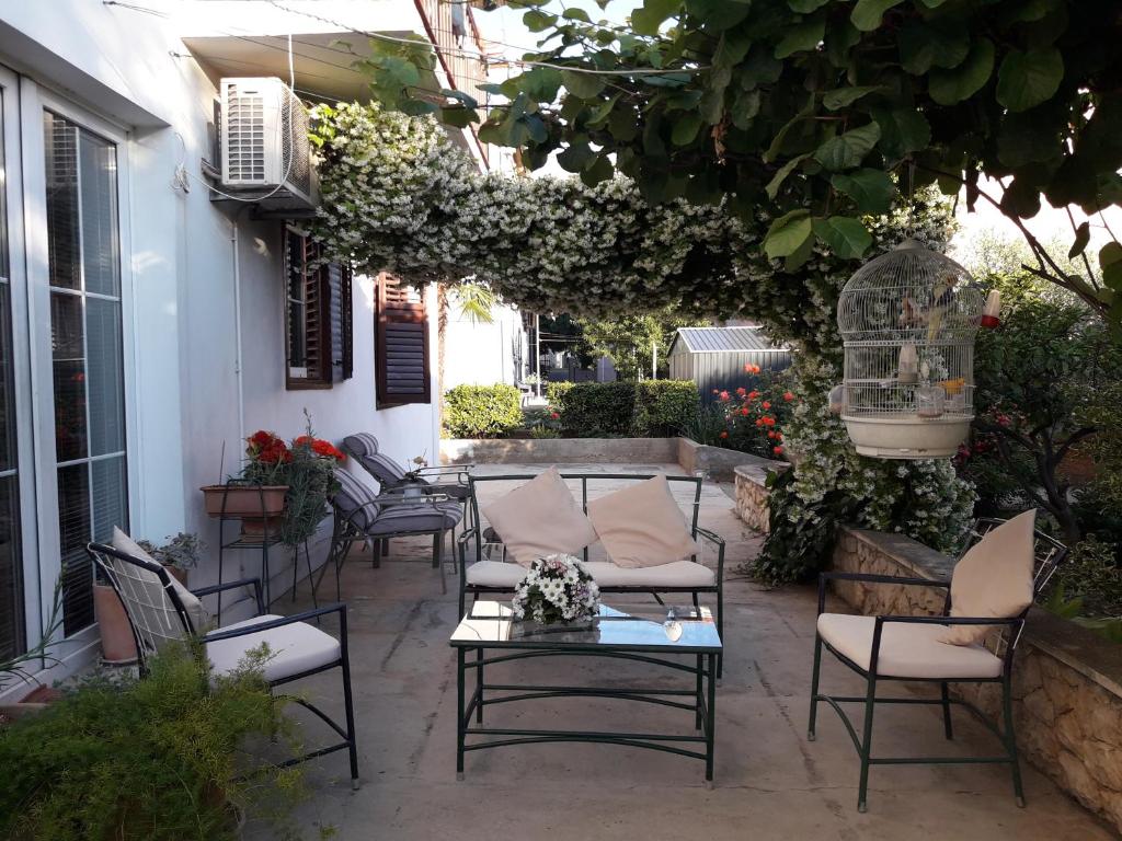 a patio with chairs and a table and flowers at Apartment Hela in Zadar