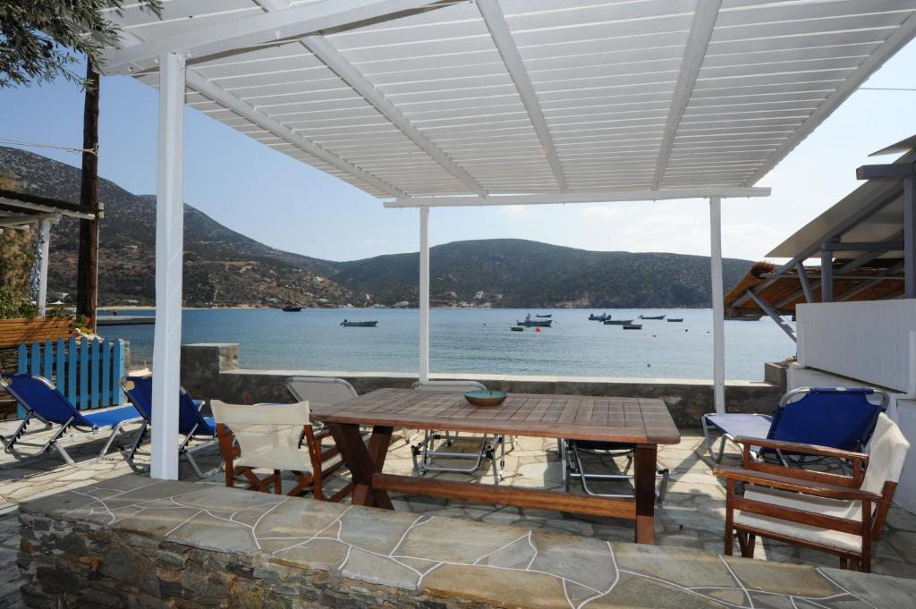 a patio with a table and chairs and a view of the water at Agrilia Apartments & Studios in Vathi