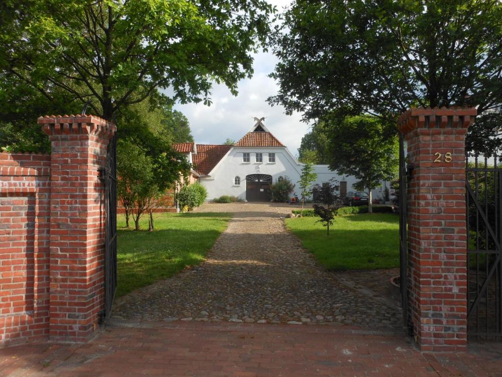 an entrance to a white house with a brick gate at Apartment Obelix in Holtorf