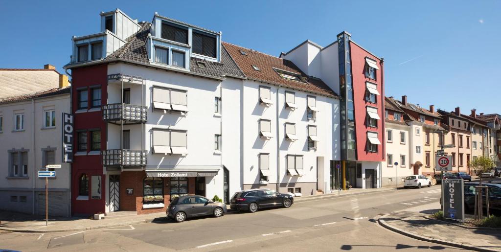 eine Stadtstraße mit Autos, die vor einem Gebäude geparkt sind in der Unterkunft Design Hotel Zollamt in Kaiserslautern