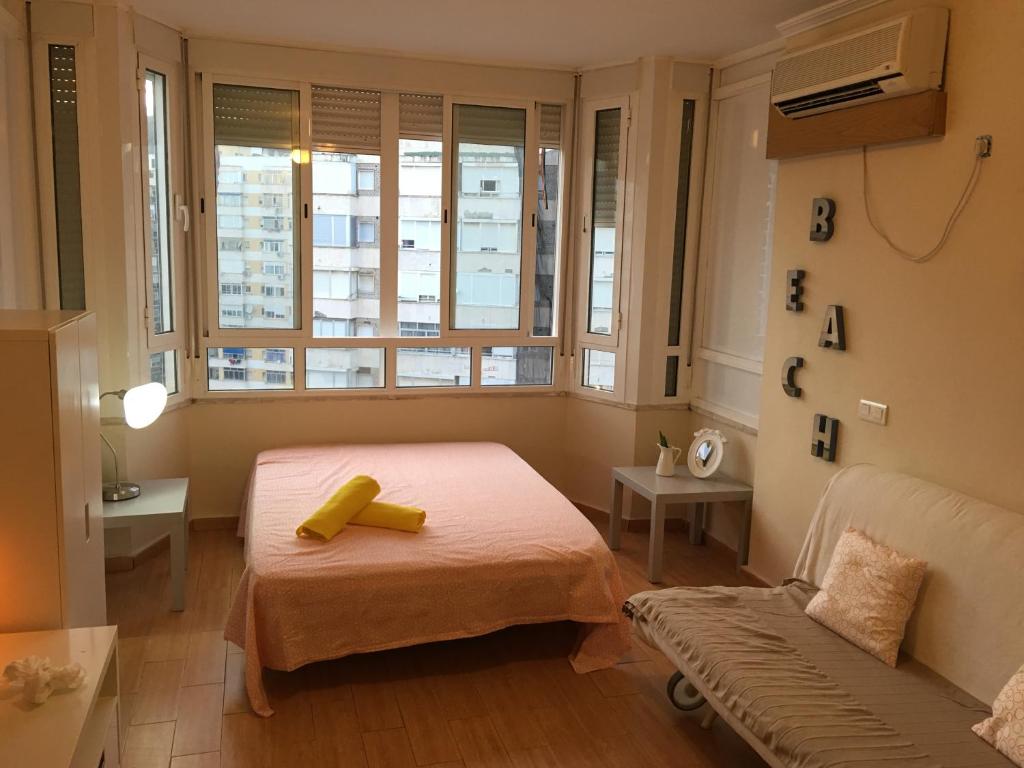 sypialnia z łóżkiem, kanapą i oknami w obiekcie Estudio Hoyo w mieście Torremolinos
