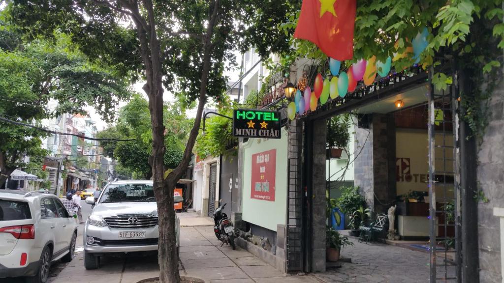 un cartel para un hotel en una acera junto a una calle en Khách sạn Minh Châu - Hòa Hưng en Ho Chi Minh