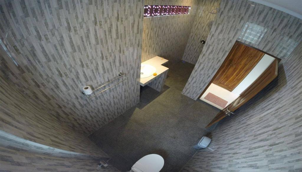 Una vista aérea de un baño con lavabo y espejo. en Lucky Family Cottage, en Ubud