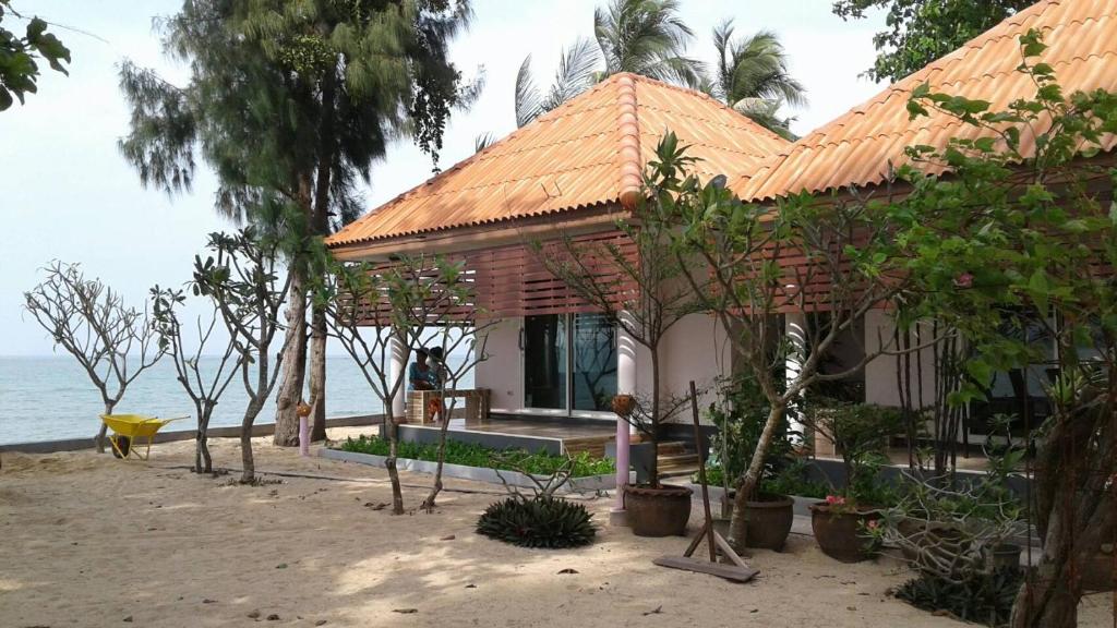湄南的住宿－湄南別墅酒店，海滩上一座带橙色屋顶的房子