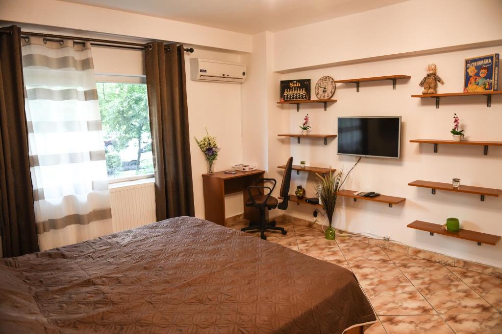 - une chambre avec un lit, un bureau et une télévision dans l'établissement Chic Apartment Near City Center, à Cluj-Napoca