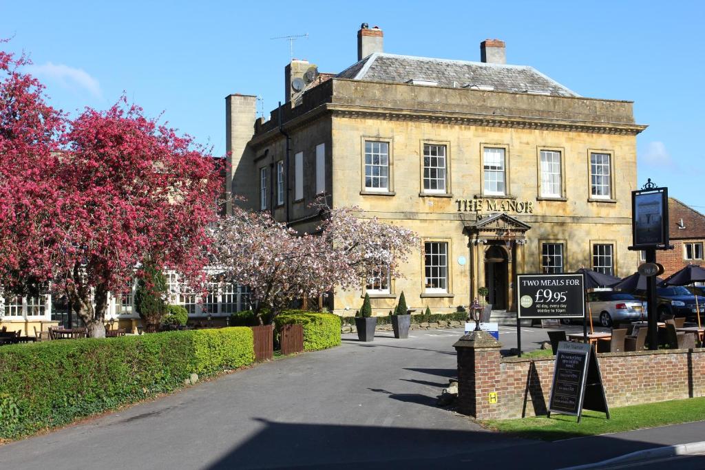 um edifício antigo com um sinal em frente em Manor Hotel by Greene King Inns em Yeovil