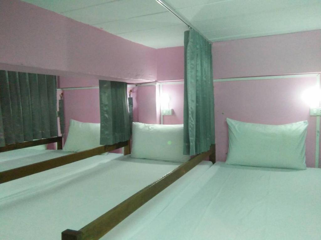 um quarto com 2 beliches num quarto cor-de-rosa em Lucky Homestay em Haad Rin