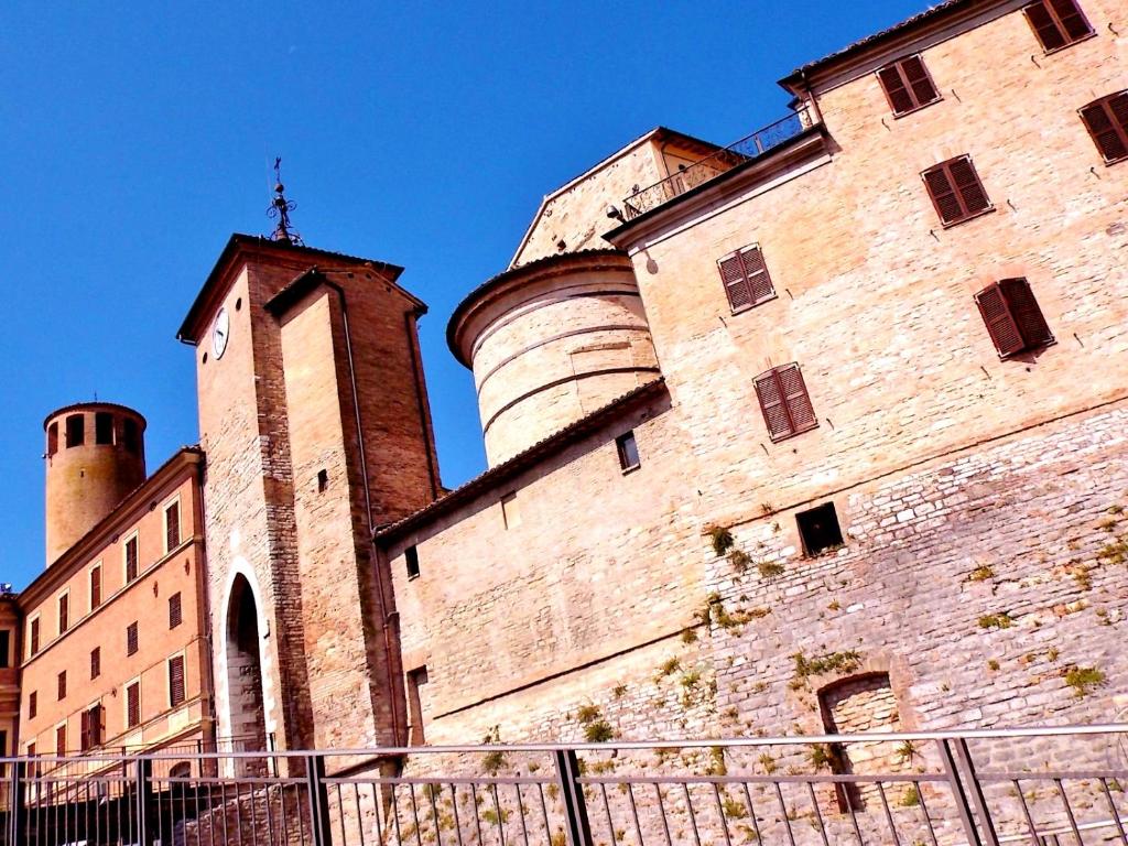 a building with two towers and a clock tower at San Lorenzo in Cerreto dʼEsi