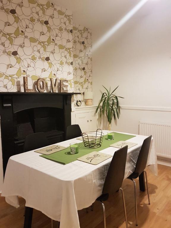 een eetkamer met een witte tafel met stoelen bij Tynant House- Modern 3 bed house- City centre and FREE parking in Cardiff