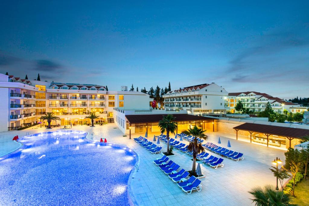un complejo con piscina, tumbonas y palmeras en Kemer Dream Hotel, en Kemer