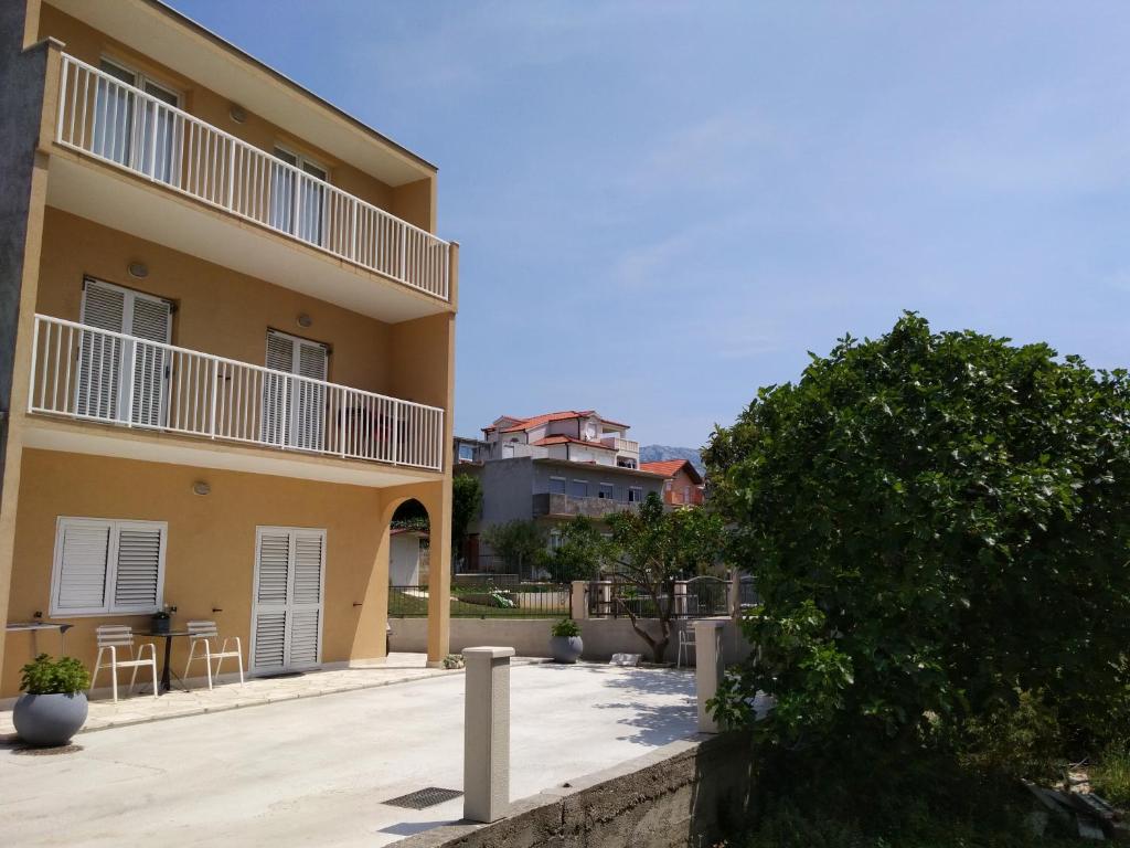 ein großes Apartmenthaus mit einer Terrasse und einem Baum in der Unterkunft Apartment Filip Vedran in Split