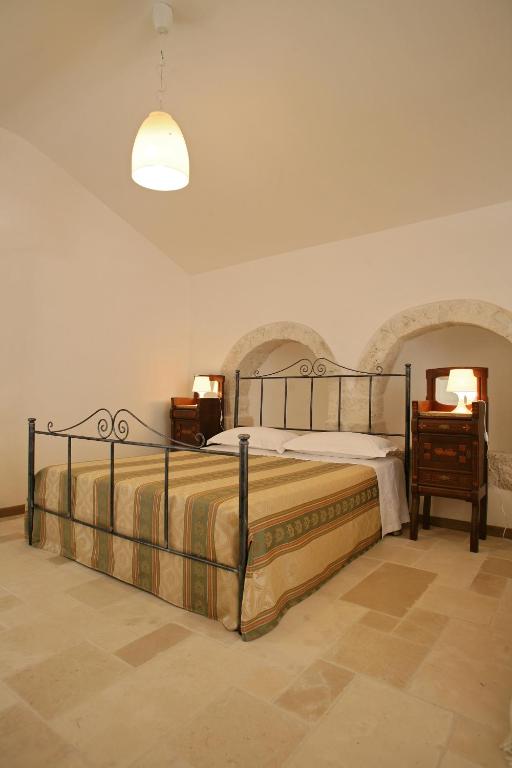 sypialnia z łóżkiem, stołem i lampą w obiekcie Grotta Cilicia B&B w mieście Noci