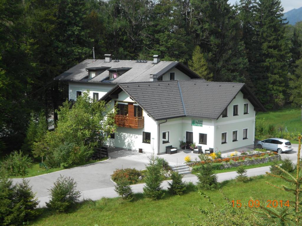 uma casa branca com um telhado preto em Pension Wanderruh em Grünau im Almtal