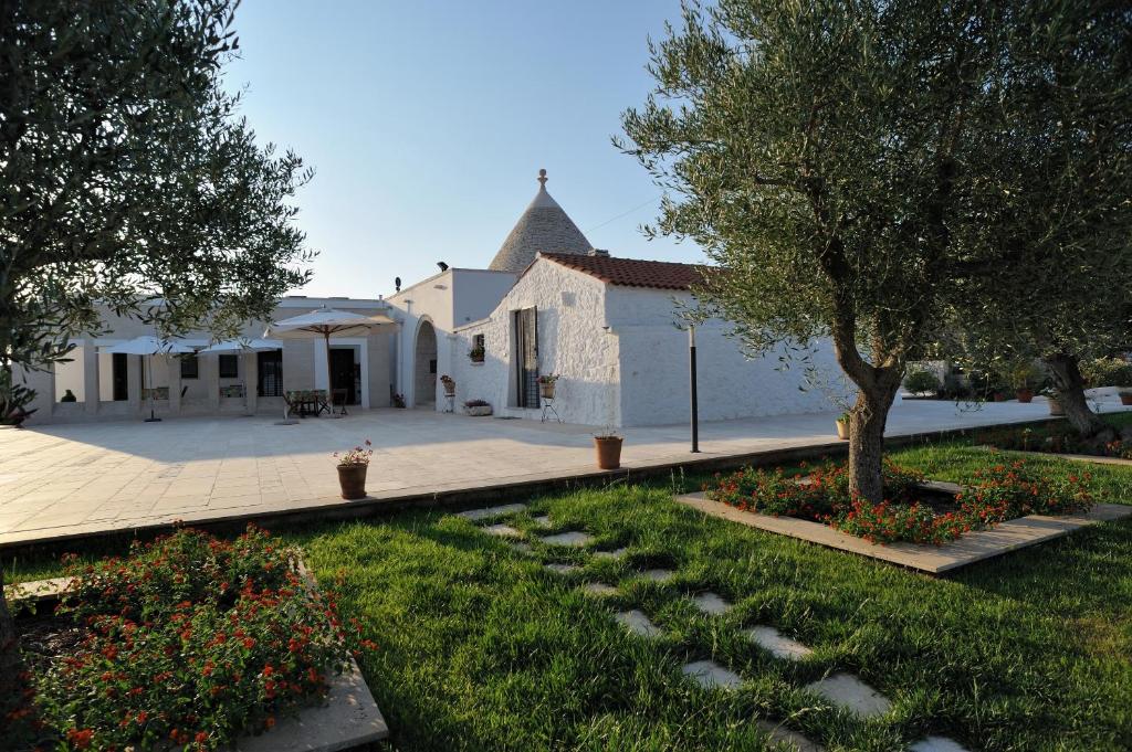 budynek z drzewem i ogródek z kwiatami w obiekcie Grotta Cilicia B&B w mieście Noci