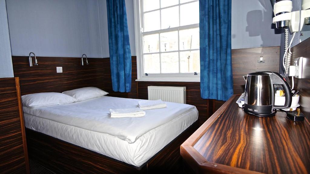 a bedroom with a bed and a table with a coffee maker at Crestfield Hotel in London