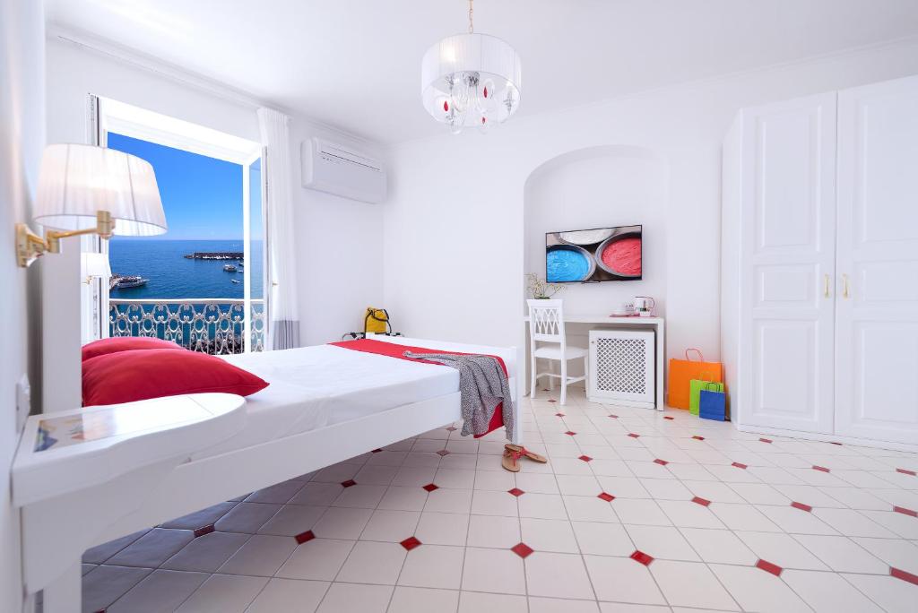 a white bedroom with a bed with a view of the ocean at Vista d'Amalfi in Amalfi