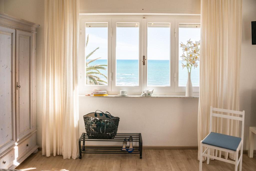 een kamer met een raam met uitzicht op de oceaan bij B&B Livia in Castiglione della Pescaia