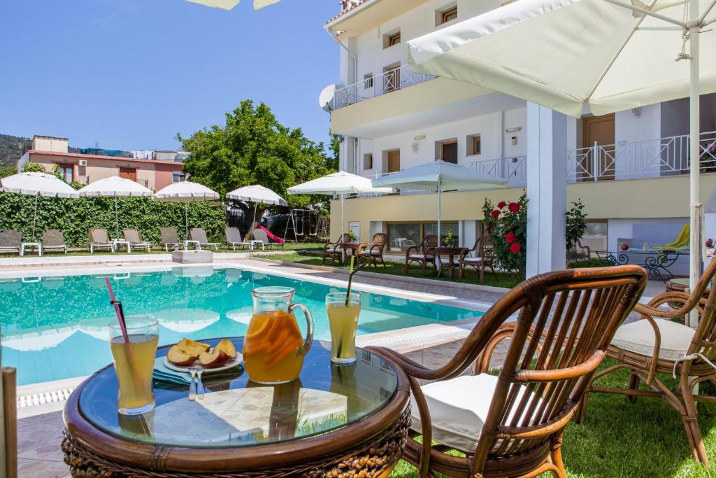 a table with drinks on it next to a swimming pool at Ritsa Studios in Skiathos Town