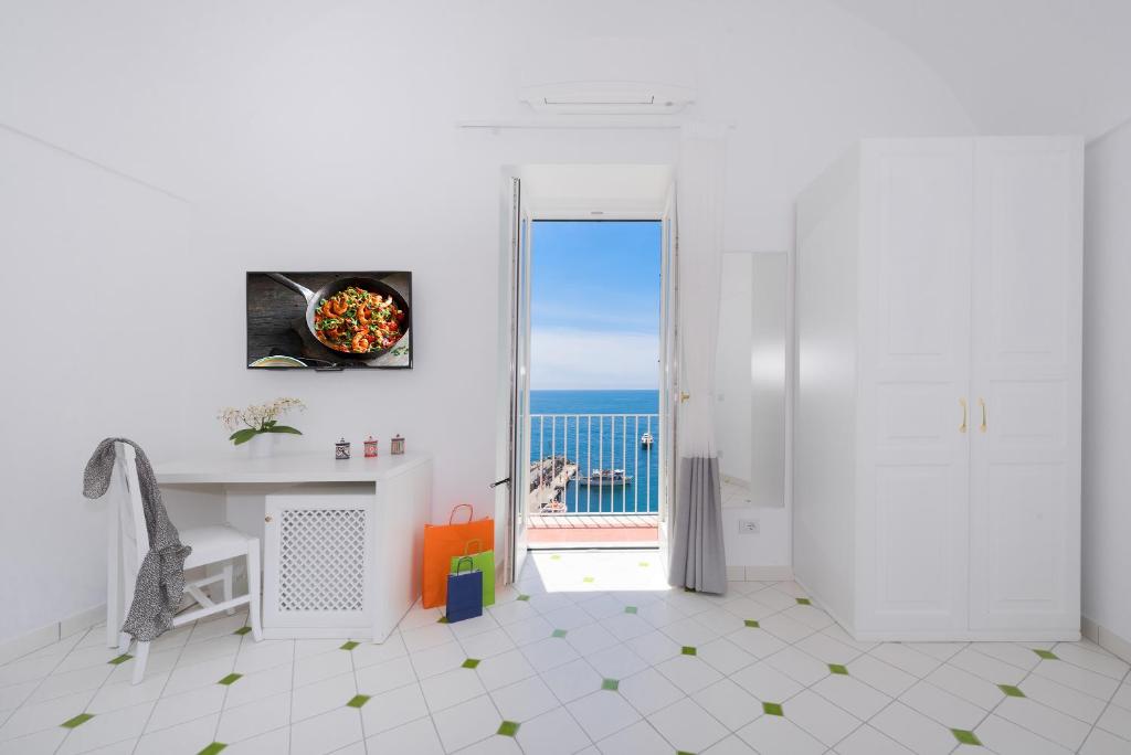 a white room with a door open to a view of the ocean at Vista d'Amalfi in Amalfi
