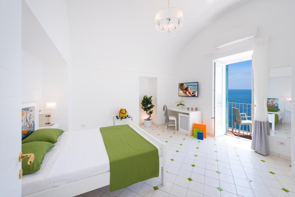 a white bedroom with a bed and a balcony at Vista d'Amalfi in Amalfi
