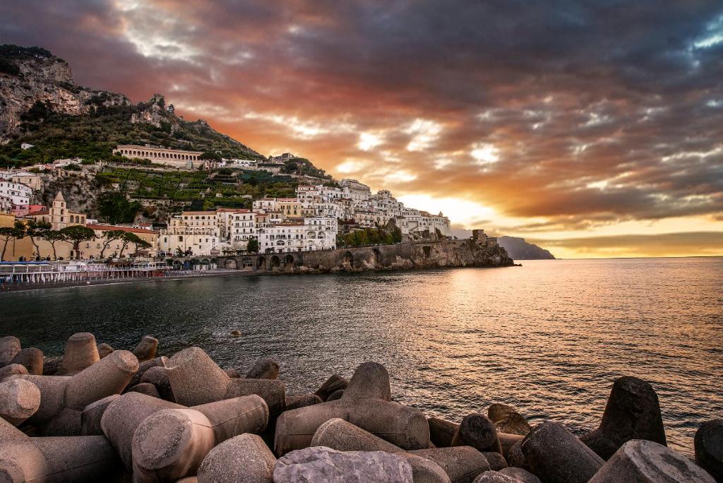 a group of buildings on a hill next to the water at Vista d'Amalfi in Amalfi
