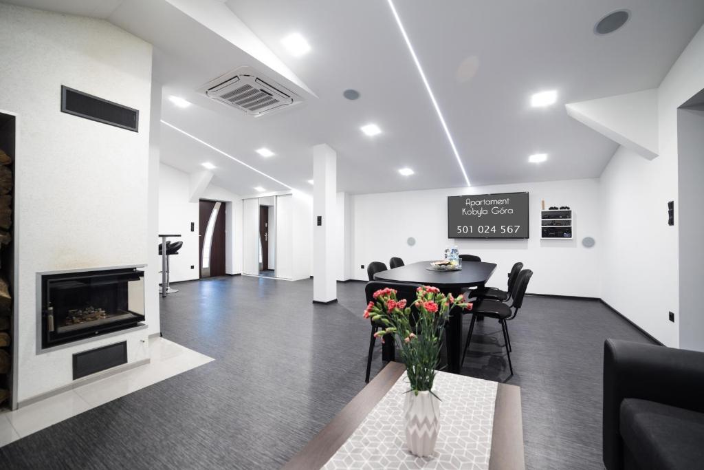 a living room with a table and a fireplace at Apartament Iwona in Kobyla Góra