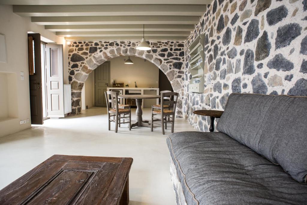 a living room with a couch and a table with chairs at Moustafa Stone House in Emporeiós