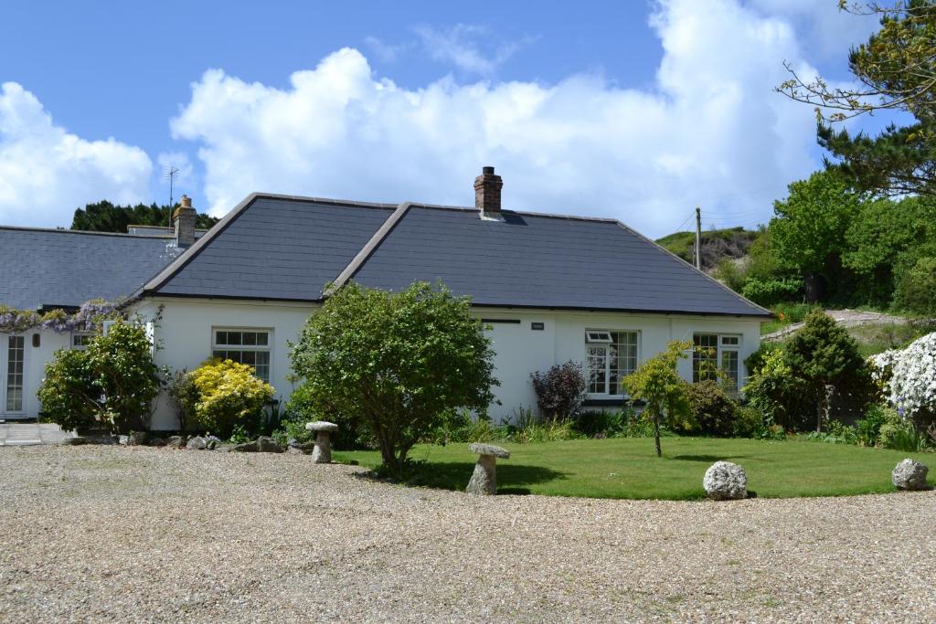 a white house with a gravel driveway at Nanis in Crantock