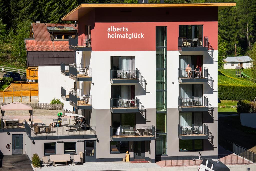 um edifício de apartamentos com uma placa que lê objectos entrelaçados em Alberts Heimatglück em Nauders