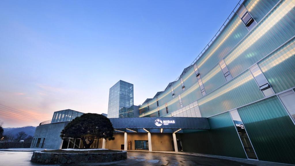 um edifício com uma árvore em frente em Midas Hotel & Resort em Gapyeong