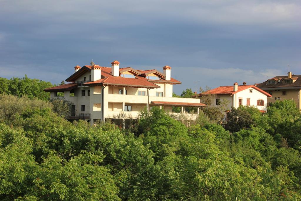 een gebouw bovenop een heuvel met bomen bij Residence Oliveto Mare Carso in Sistiana