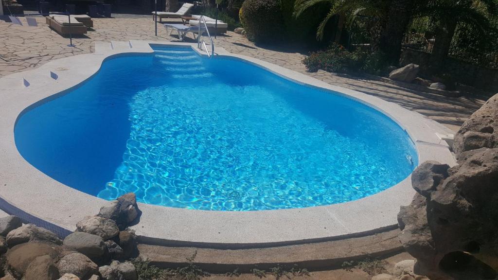 a swimming pool with blue water in a yard at Pao Blau in Pau