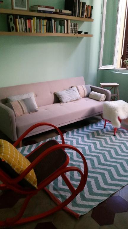 ein Wohnzimmer mit einem rosa Sofa und einem Stuhl in der Unterkunft Oltretorrente 15 in Parma