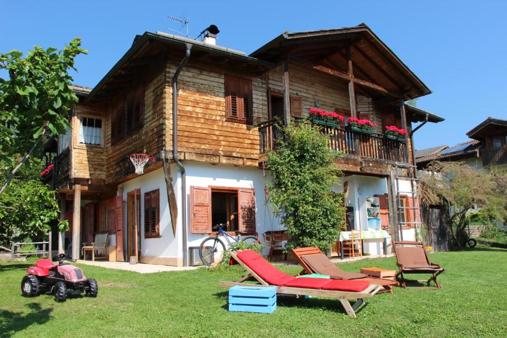 dom z krzesłami i motocyklem przed nim w obiekcie B&B Casa Delle Fate w mieście Campodenno