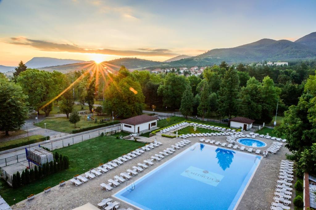 uma vista aérea de um resort com uma piscina e um pôr-do-sol em SPA Hotel Medicus em Varshets