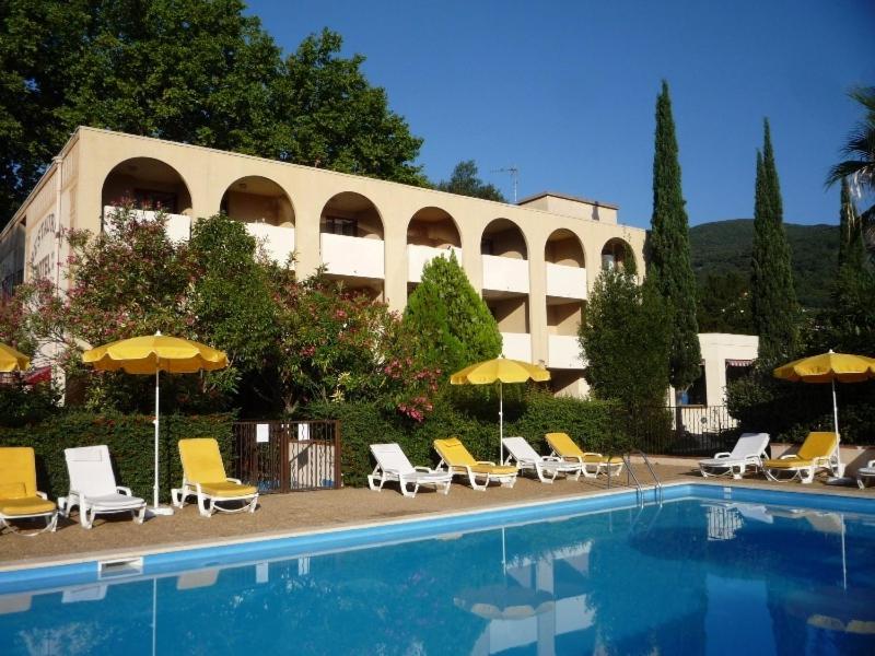 un grupo de sillas y sombrillas junto a una piscina en Le Roussillon, en Amélie-les-Bains-Palalda