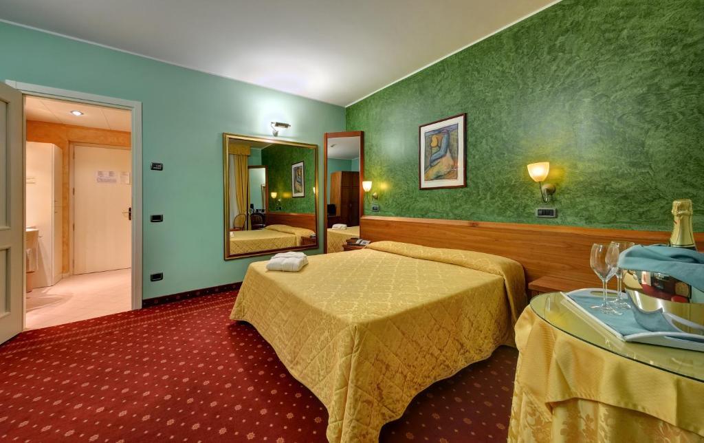 Habitación de hotel con 2 camas y espejo en Hotel Motel Sporting en Montodine