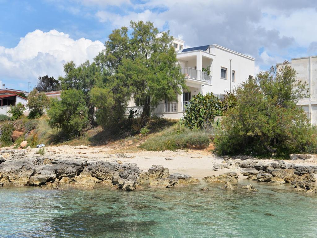 una casa blanca en una playa junto al agua en Luxury Beach Villa Puglia Italy, en Pulsano