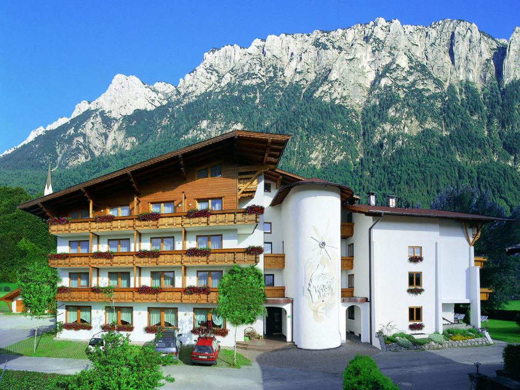 un hotel con una montaña en el fondo en dasKAISER - Dein Gartenhotel in Tirol, en Ebbs