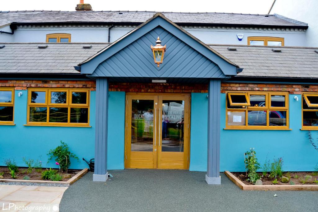 una casa azul con puerta amarilla en The Ugly Duckling, en Telford